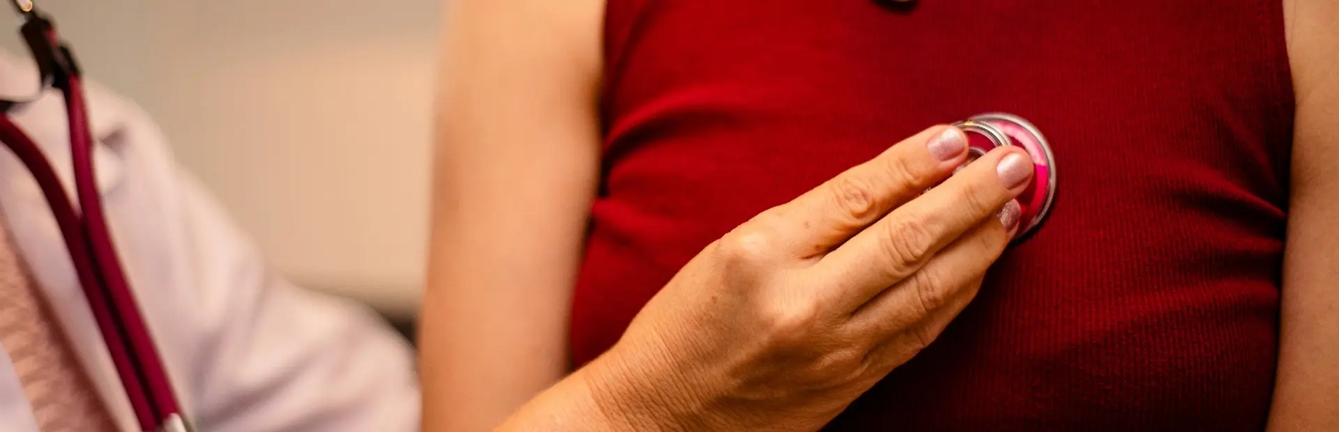 Een arts luistert naar het hart van een patiënt 