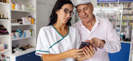 Apotheker helpt klant met voorschriftmedicijn