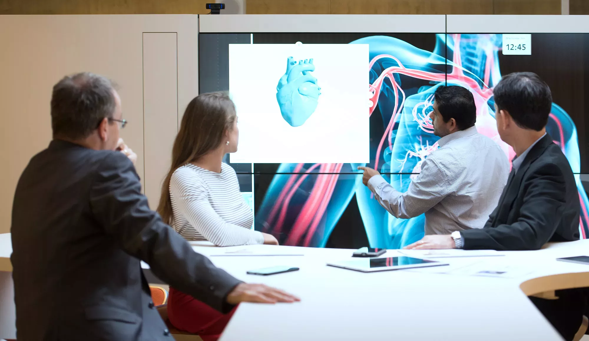Колеги се взират в екран с 3D сърце 