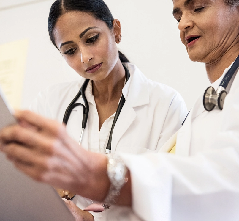 Foto de duas mulheres médicas olhando para baixo com foco em um ponto.
