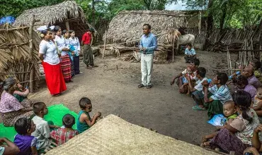 Um homem ensina uma comunidade em Mianmar sobre conscientização e prevenção da hanseníase