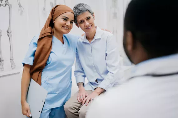 A nurse and a patient engaged in a hug