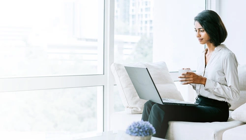 Eine Geschäftsperson mit einem Computer sitzt in einem Sofa