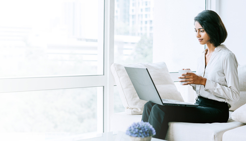 Eine Geschäftsperson mit einem Computer sitzt in einem Sofa
