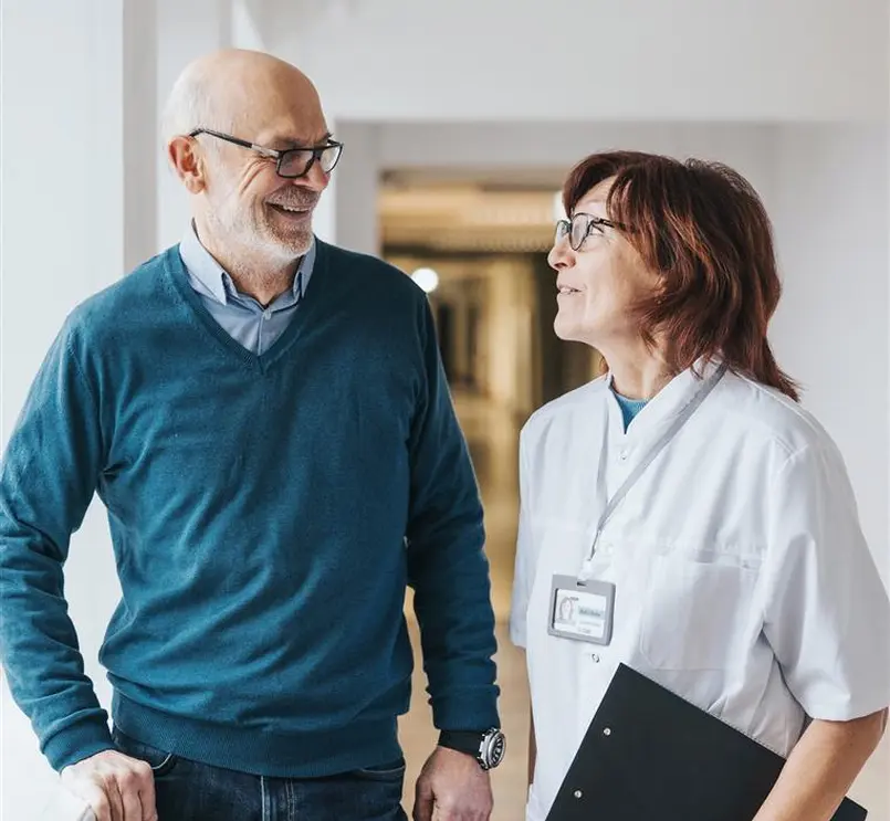 Zwei Personen im Gespräch in einem medizinischen Umfeld