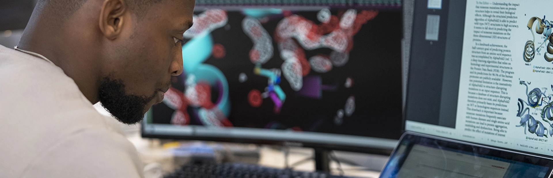 Ein Novartis Wissenschaftler sitzt vor dem Computer und baut virtuelle Modelle zur Behandlung von Krebs