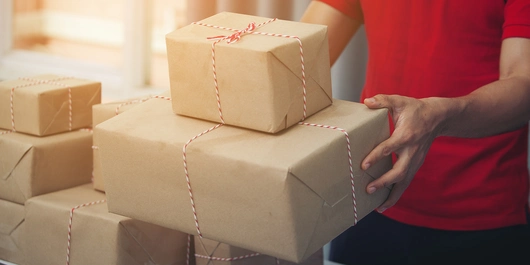 Ein Zusteller hält Pakete in seinen Händen