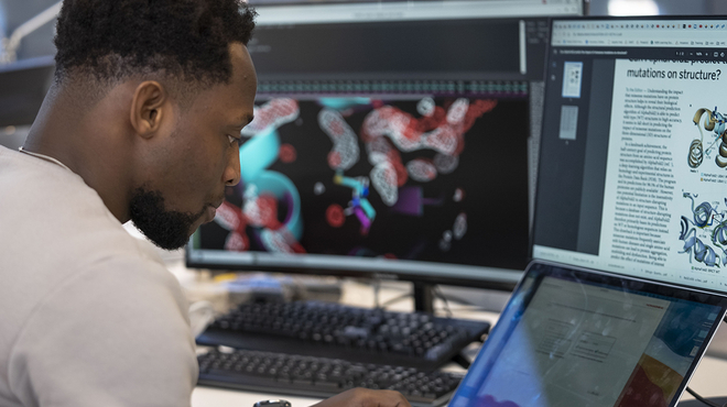 Ein Novartis Wissenschaftler sitzt vor dem Computer und baut virtuelle Modelle zur Behandlung von Krebs