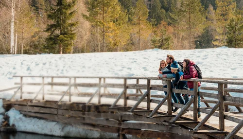 Une famille en randonnée en montagne fait une pause au bord d'un lac.