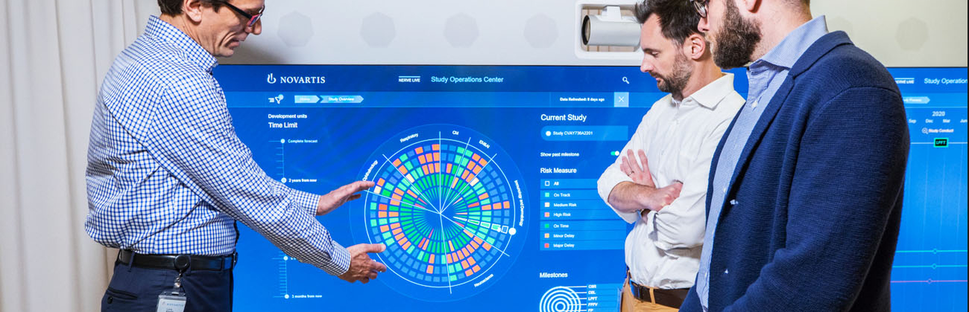 Sur un écran, le Dr. Luca Finelli présente à son équipe l'interface du module prédictif Sense