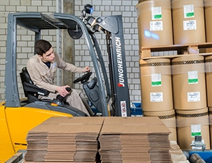 Un apprenti transporte des marchandise dans le stock