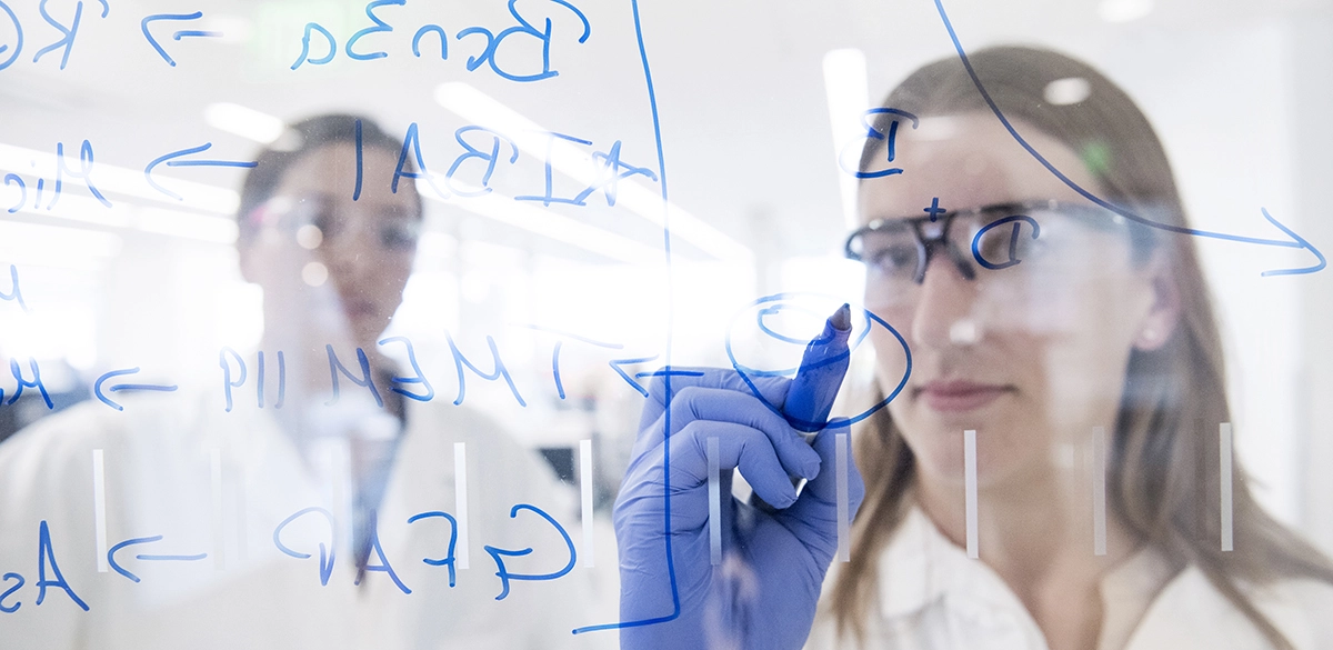 Wissenschaftlerin schreibt an einer Glaswand