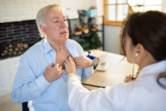 Eine Ärztin untersucht einen Patienten mit einem Stethoskop