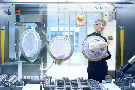 Eine Produktionsmitarbeiterin in Schutzkleidung arbeitet unter steriler Atmosphäre