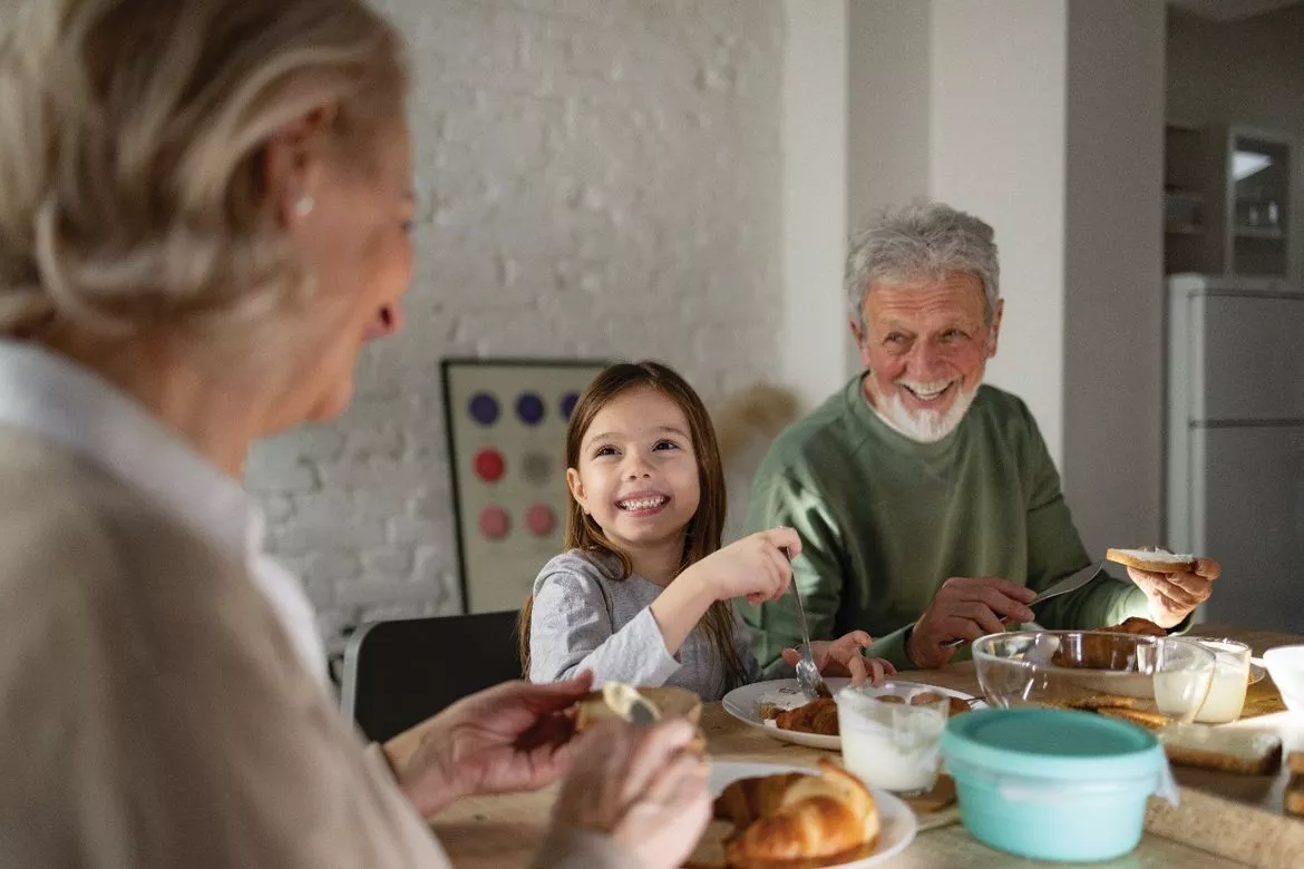 Little girl having breakfast with grandparents