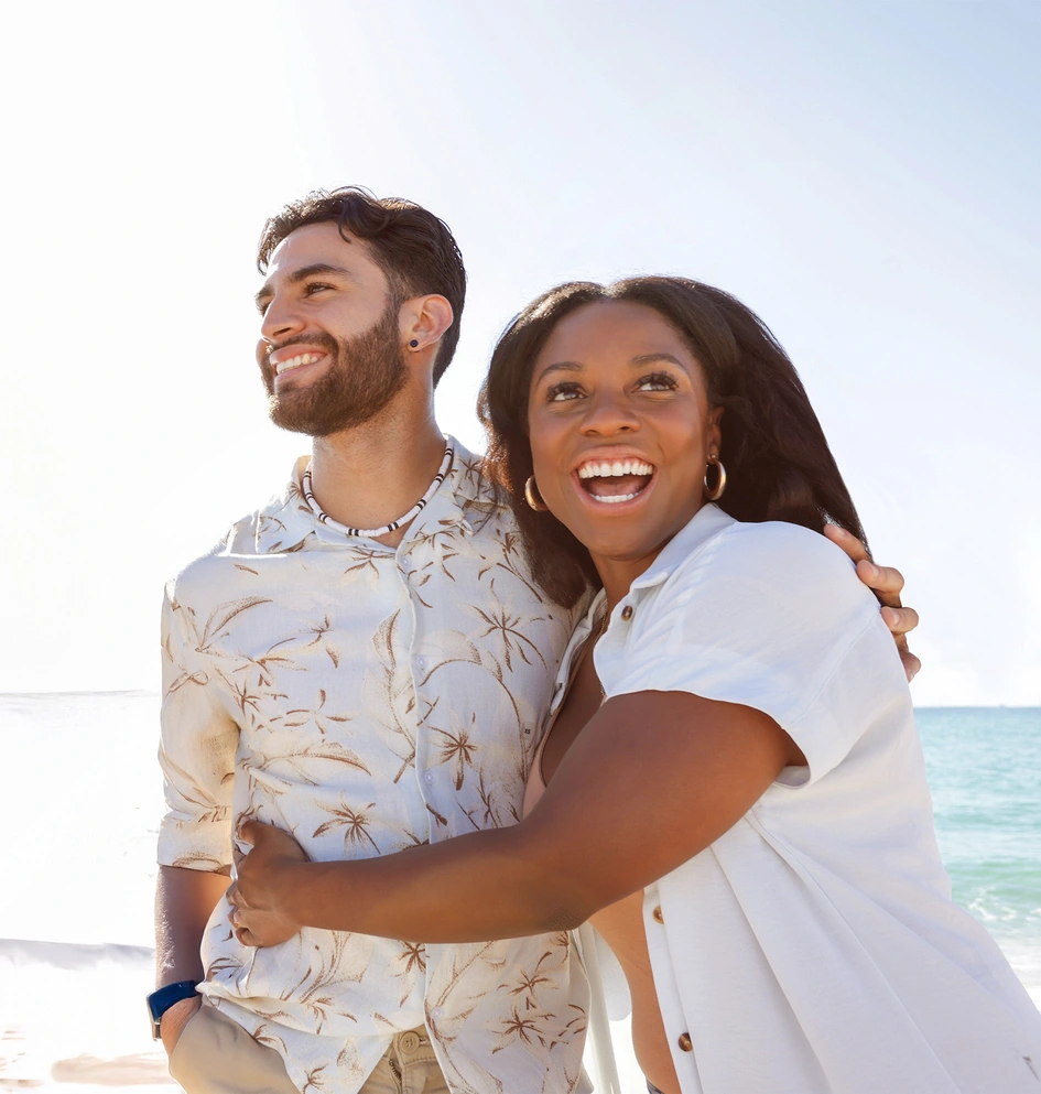 Junges Paar bei einem Spaziergang am Meer bei Sonnenuntergang