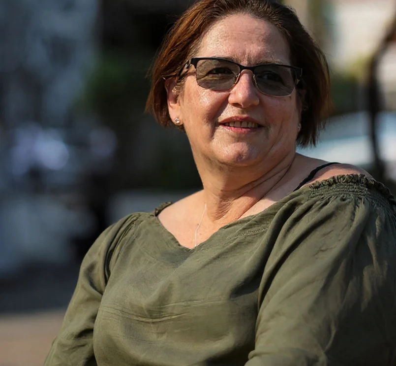 Person sitzt draußen im Sonnenlicht.