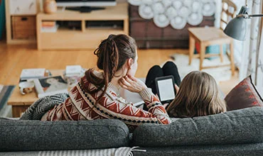 Mutter mit Kind Zuhause am Smartphone