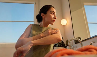 Spiegelbild eines Patienten im Badezimmer mit Handtuch und Fensterblick.