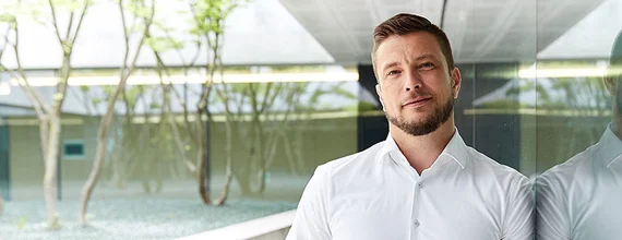 Mann in weißem Hemd schaut in die Kamera