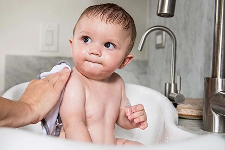 Ein Baby wird in einer Badewanne gewaschen