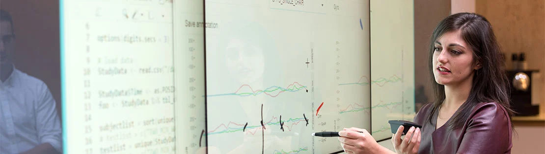 Frau erklärt an einem Whiteboard einen Graphen