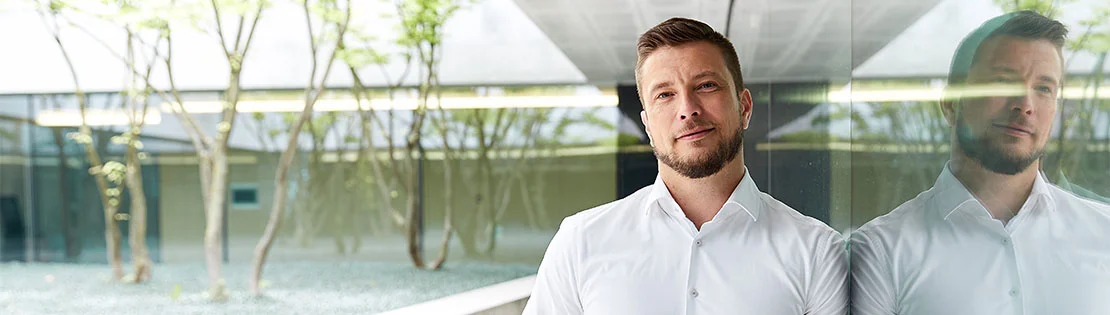 Mann in weißem Hemd schaut in die Kamera