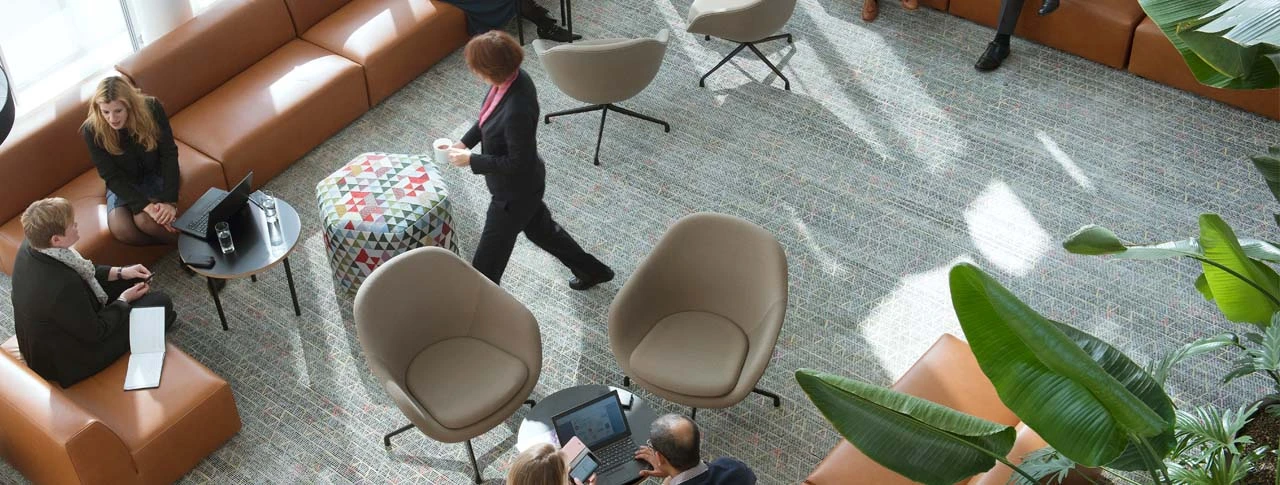 Ein modern eingerichteter Meetingraum in dem sich drei Kollegen treffen