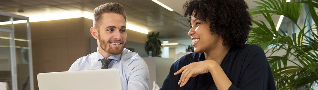 Zwei Kolleg*innen bei der Arbeit am Laptop