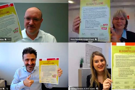 Vier Mitarbeiter von Novartis sind in einem Online Meeting und halten die "Charta der Gleichstellung" hoch