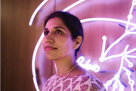 Eine Frau vor einer pinken Reklame