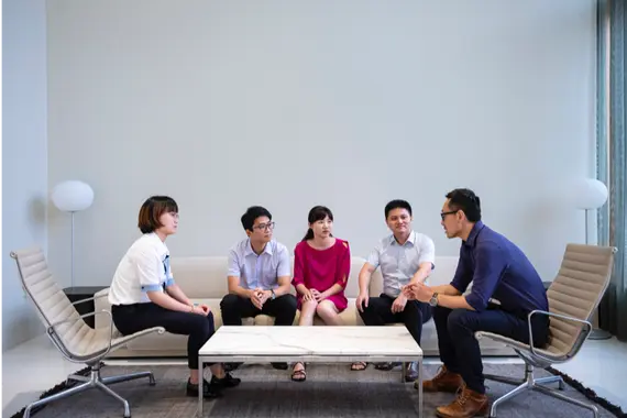 Fünf Kollegen besprechen sich in einem Meeting