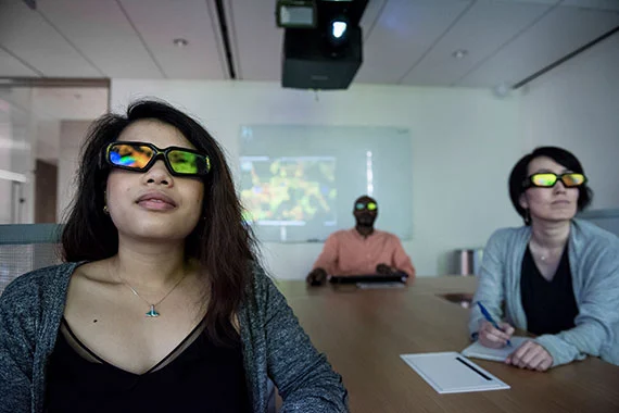 Drei Mitarbeiter schauen ein Video