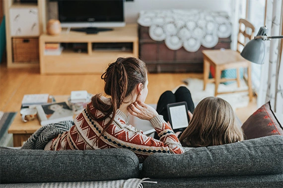 Mutter und Tochter lesen auf dem Tablet