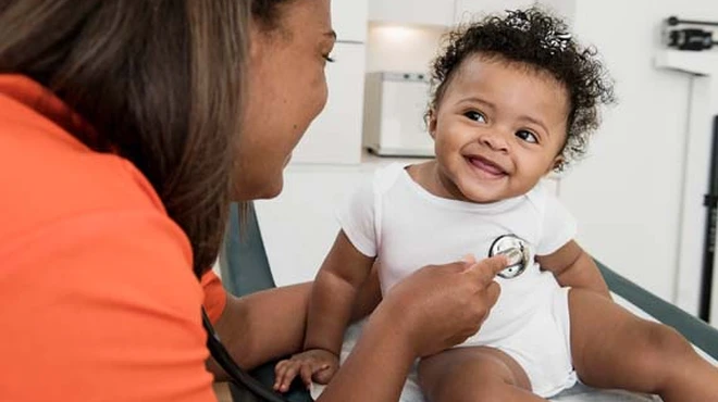 Aerztin hoert Herzschlag eines Baby ab