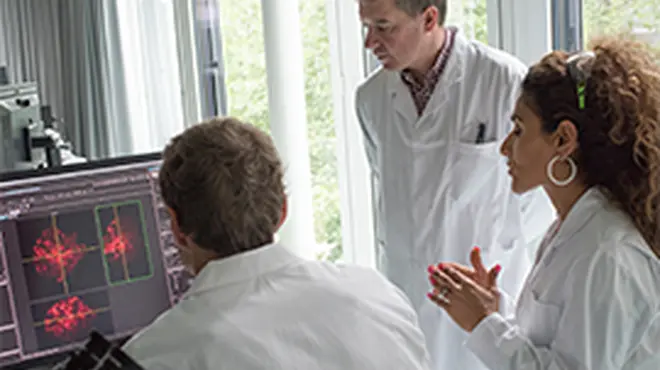 overview wissenschaftler diskutieren vor mikroskop