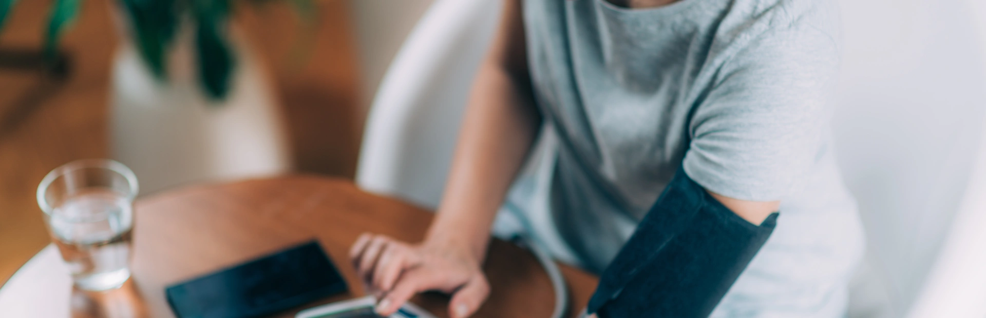 Mujer mayor tomándose la tensión en su casa