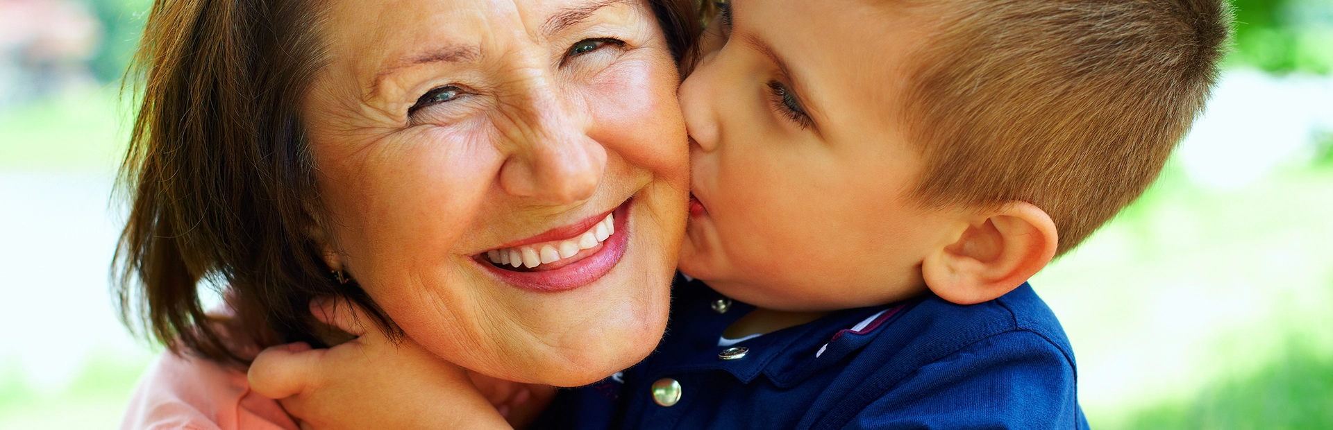 Niño dando un beso a su abuela