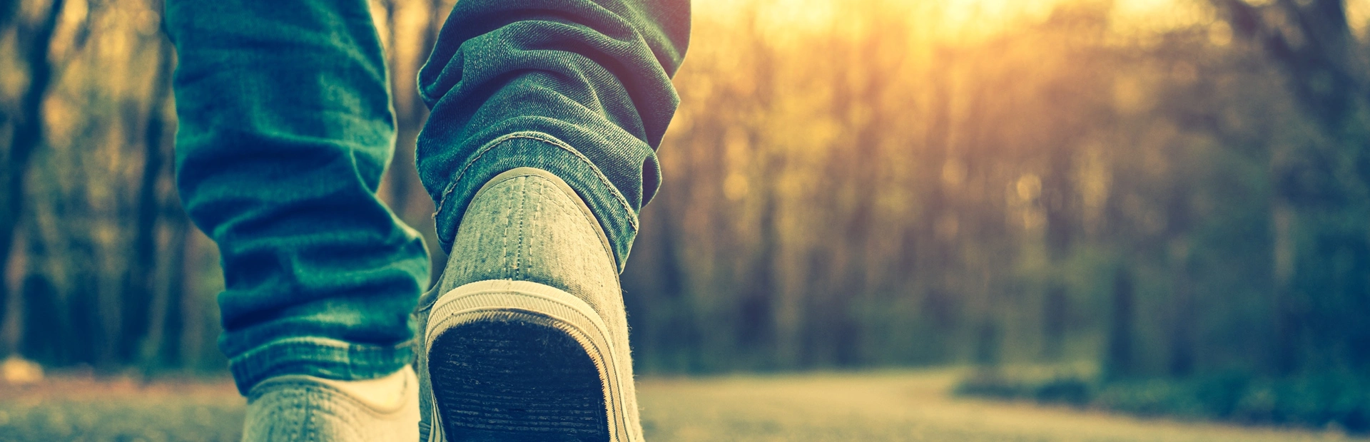 Pies caminando por un camino en el bosque