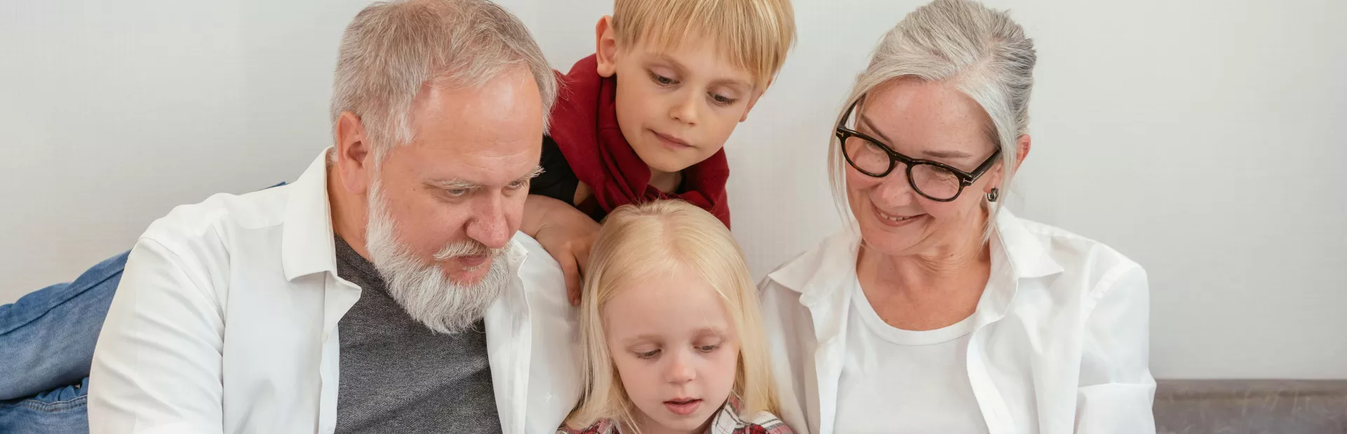 Abuelos leyendo junto a sus nietos