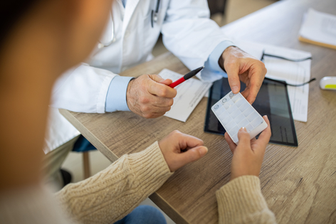 Doctor brindando receta médica a una paciente