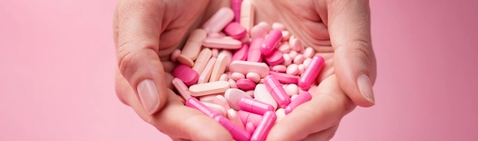 manos sujetando pastillas rosas