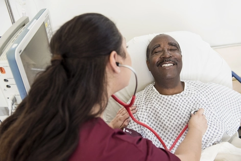 Enfermera escuchando los latidos de un hombre