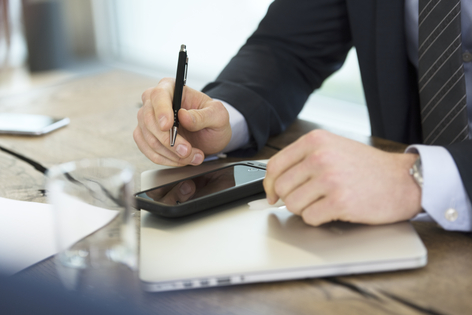 Ejecutivo escribiendo y revisando el móvil