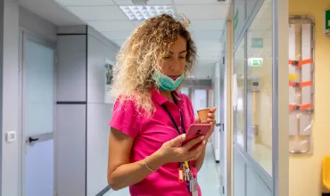 Profesional de la salud revisando su móvil en el hospital