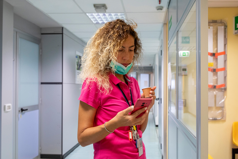 Profesional de la salud revisando su móvil en el hospital