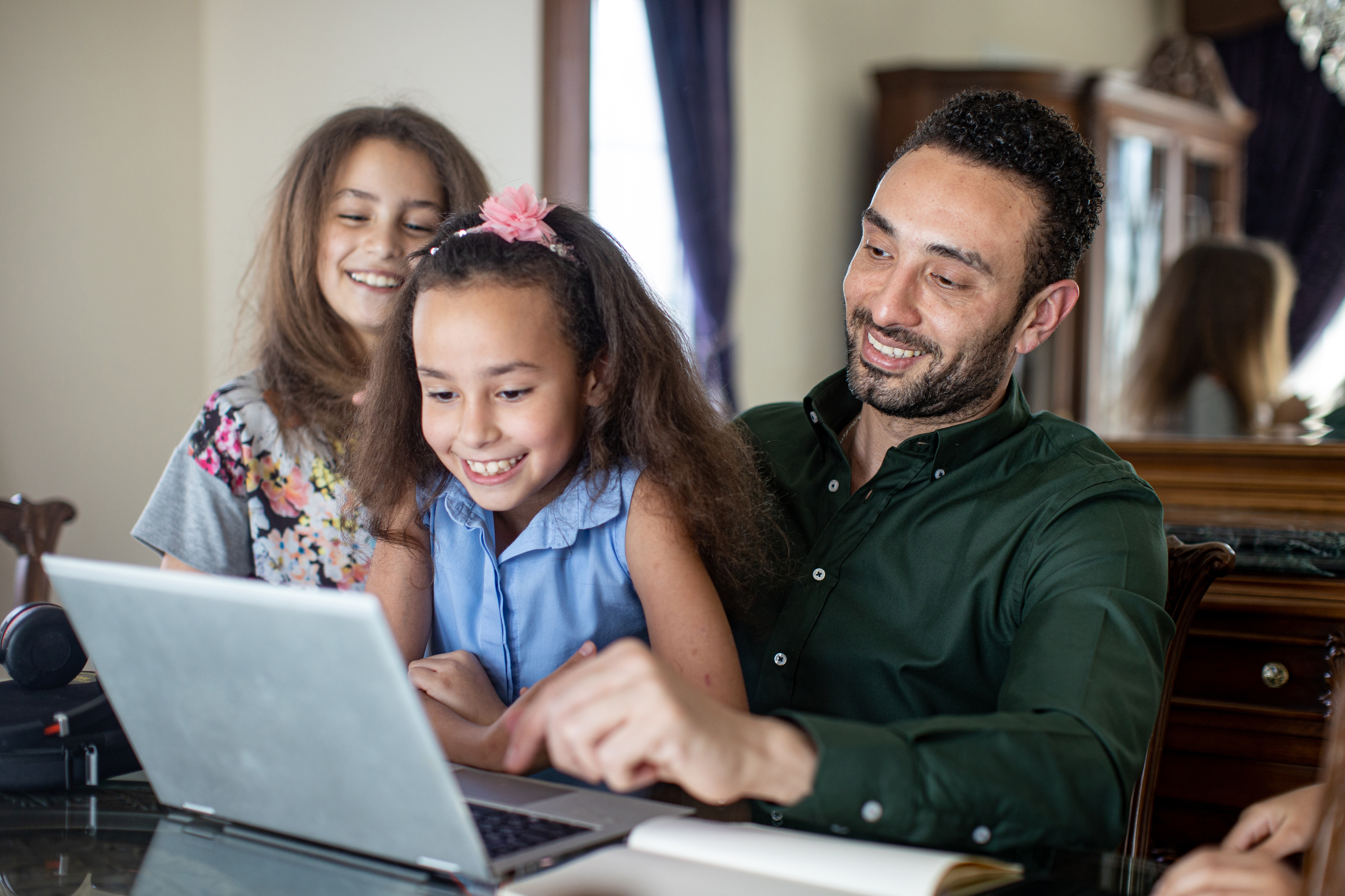 Familia sonriendo frente al ordenador