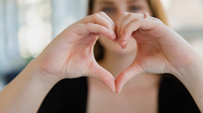Mujer haciendo símbolo de corazón con sus manos