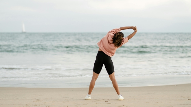 Mujer estirando en la playa