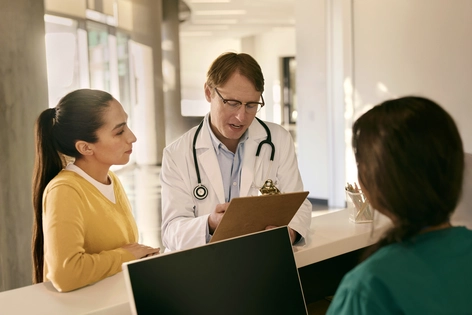 Doctor consulting with a patient at reception desk